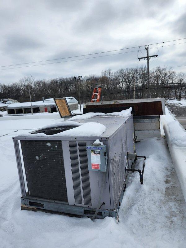 Responded to multiple no-heat calls affecting bar room unit, vending machine thermostat, and pro shop. Inspection revealed severely weathered rooftop units with extensive rust damage and deterioration, likely compromised by harsh winter conditions with visible snow accumulation around equipment. Documented current condition of equipment for potential replacement recommendation.