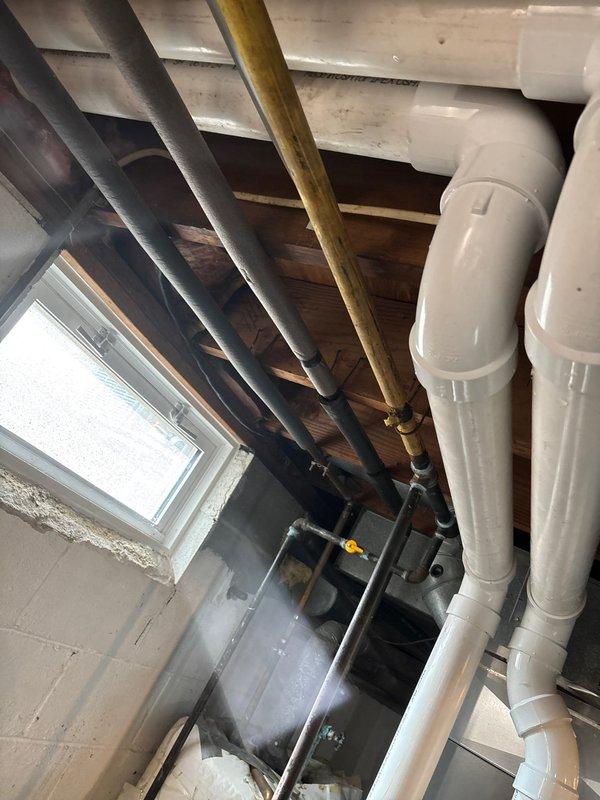 Completed installation of a new Lennox HVAC system in basement utility area, including furnace unit with proper sheet metal ductwork connections and PVC venting pipes. System was integrated with existing plumbing infrastructure, with all components properly secured to concrete block walls and ceiling joists for optimal performance.