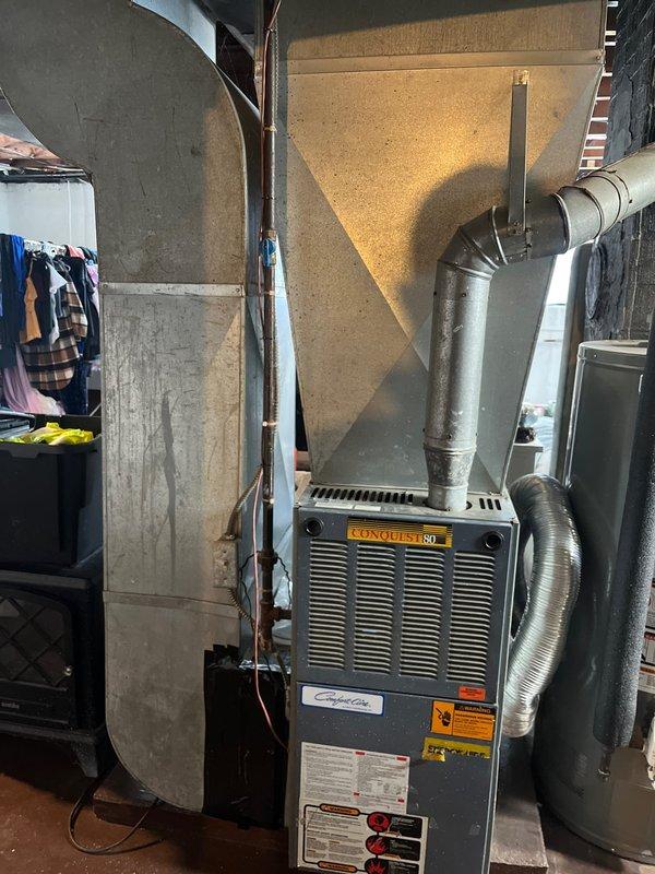 Performed inspection of 45-year-old Conquest 80 furnace system to prepare estimate for replacement. Evaluated existing ductwork configuration, noting inadequate return air and missing bathroom supply. Documented current installation with photos showing outdated plenum design and suboptimal duct routing through floor joists. Customer requires comprehensive quote for new furnace, A/C unit, dehumidifier, and correction of existing ductwork deficiencies.