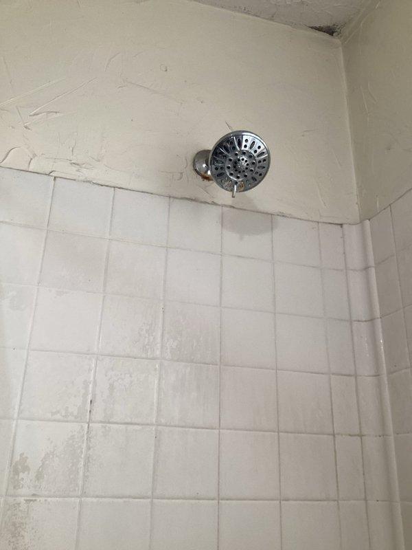 Responded to client request for shower plumbing service regarding water drainage issue. Inspected white bathtub and shower assembly with chrome fixtures showing signs of age and mineral deposits. Resolved drainage problem that was causing water to hold in tub, restoring proper water flow and functionality.