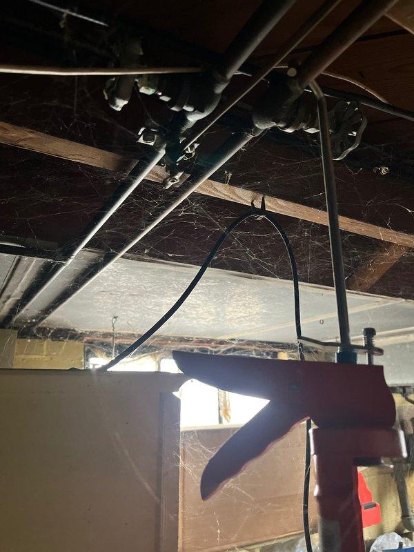 Conducted assessment of aging HVAC system in basement utility area. Recommended replacement with 80% efficient furnace and 13 SEER air conditioning unit. Noted significant dust accumulation on ceiling joists and potential ventilation issues with existing exhaust pipes that would be addressed during installation.