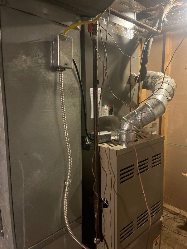 Conducted inspection of existing HVAC system in unfinished construction space, documenting the current furnace installation and ductwork configuration. Provided replacement estimate for upgrading the aging furnace unit, which includes replacement of the metal cabinet unit and optimization of the curved metallic ductwork system with proper insulation for improved efficiency.