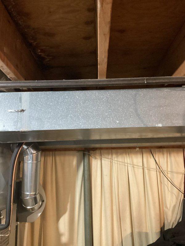 Conducted site assessment for potential tankless water heater installation. Inspected existing gas meter showing signs of corrosion and weathering with "EAST OHIO GAS CO." identification. Evaluated basement infrastructure including exposed ceiling joists, support beams, and existing ductwork to determine appropriate installation location and required modifications.