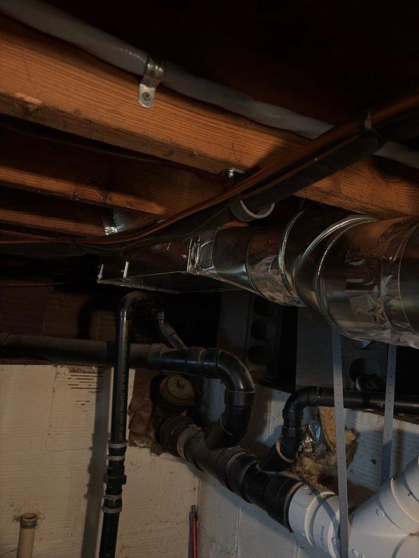 Completed installation of new HVAC system in residential basement, including mounting of galvanized sheet metal ductwork secured to ceiling joists with metal brackets and proper connection to existing ventilation infrastructure. System was successfully integrated with home's plumbing and mechanical components, with all connections properly sealed and secured.