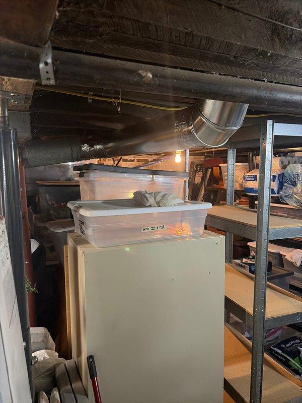 Completed installation of new HVAC system in residential basement, including mounting of galvanized sheet metal ductwork secured to ceiling joists with metal brackets and proper connection to existing ventilation infrastructure. System was successfully integrated with home's plumbing and mechanical components, with all connections properly sealed and secured.