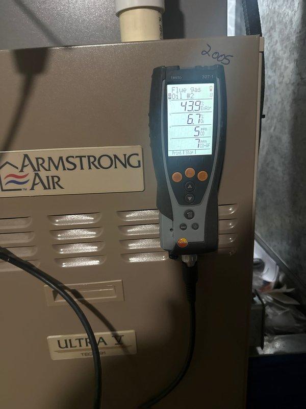 Performed clean and check service on Armstrong Air Ultra V furnace (circa 2005). Conducted flue gas analysis using Testo 327-1 analyzer, documenting readings of 439 ppm, 6.1%, 5%, and 7 points. Inspected adjacent water heater system and verified proper connections between HVAC components.