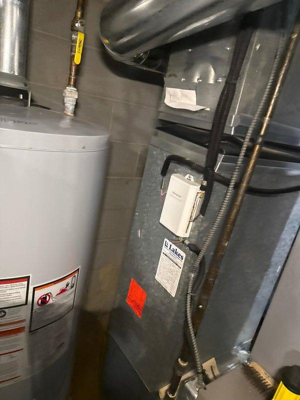 Performed clean and check service on Armstrong Air Ultra V furnace (circa 2005). Conducted flue gas analysis using Testo 327-1 analyzer, documenting readings of 439 ppm, 6.1%, 5%, and 7 points. Inspected adjacent water heater system and verified proper connections between HVAC components.