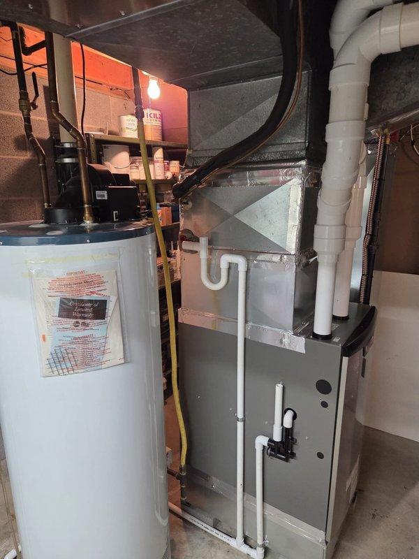 Successfully completed a Lennox furnace retrofit in residential basement utility area. Installed unit with properly sealed sheet metal ductwork connections and PVC condensate/venting system. Confirmed proper installation with adequate service clearance and verified system functionality alongside existing water heater.