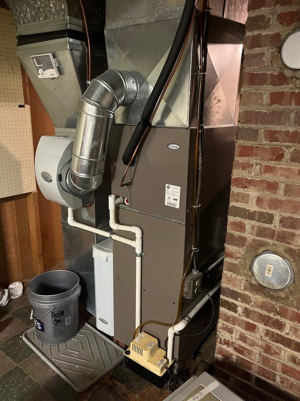Successfully completed retrofit installation of a York furnace system in basement utility area, including proper connection of dual PVC intake/exhaust ventilation pipes and integration with existing ductwork. System was installed against brick wall with all necessary components including humidifier attachment and properly vented exhaust system.