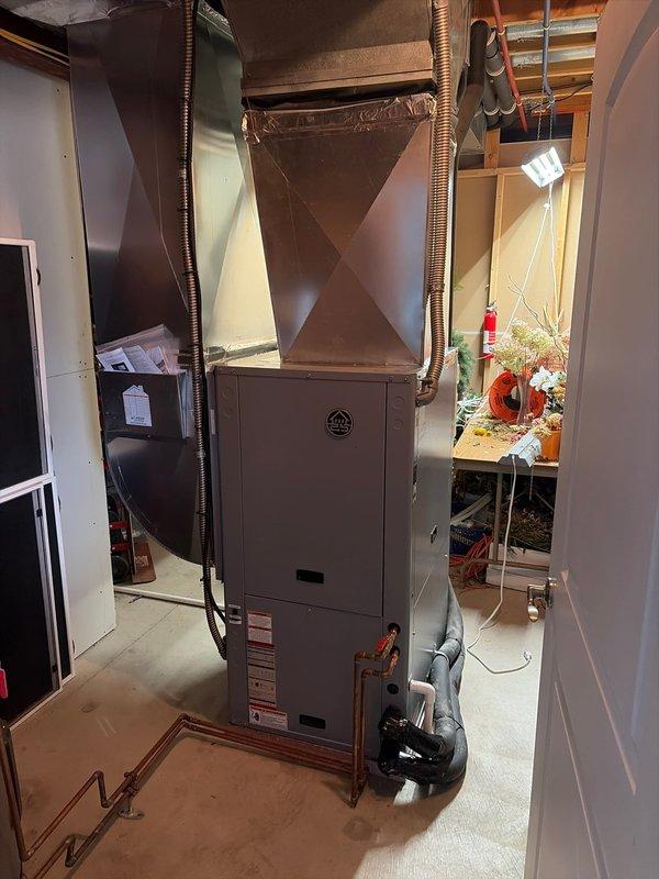 Successfully installed a new geothermal HVAC system in the basement utility room, including proper connection of the furnace unit to existing ductwork and copper piping. System features include insulated flexible ducts for efficient air distribution and a control interface with monitoring gauges, with all components securely mounted and sealed according to manufacturer specifications.