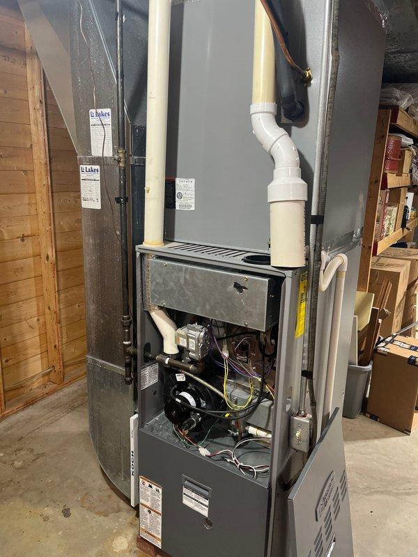 Completed furnace retrofit assessment for replacement of existing unit with larger capacity system. Current installation features an aging furnace with open access panel revealing internal components and PVC exhaust/intake pipes. Recommendation includes full system replacement due to age of components and customer's request for increased heating capacity.