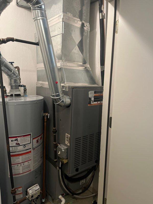 Performed site evaluation of existing HVAC system to address customer's concern about furnace sizing. Inspected current installation including furnace unit with connected ductwork, adjacent water heater system, and associated plumbing components. Documented existing equipment configuration to prepare appropriate replacement options considering natural gas efficiency and proper system sizing.