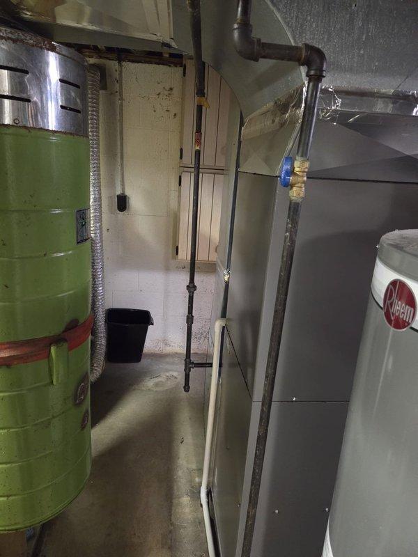 Completed furnace and AC retrofit installation in residential basement. Installed new Rheem system with PVC ventilation pipes, connected to existing ductwork, and ensured proper integration with hot water tank and associated plumbing components. System was tested and verified operational as indicated by control panel indicator light.