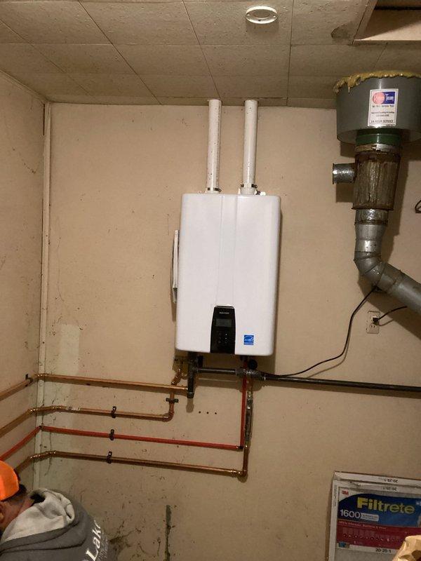 Successfully installed a new tankless water heater system with proper venting, including dual white exhaust pipes and ventilation ductwork. Completed copper pipe connections for water supply and return lines, securing all piping with appropriate mounting brackets and ensuring proper joint connections throughout the system.