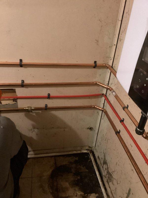 Successfully installed a new tankless water heater system with proper venting, including dual white exhaust pipes and ventilation ductwork. Completed copper pipe connections for water supply and return lines, securing all piping with appropriate mounting brackets and ensuring proper joint connections throughout the system.