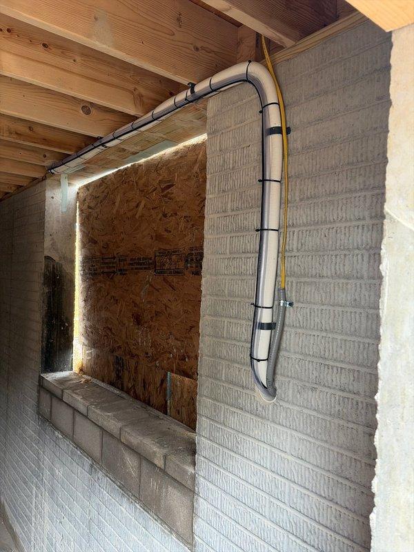 Successfully installed a mini-split air conditioning system on a newly constructed drywall section, with the indoor unit properly mounted and secured. Completed installation of metal conduit with electrical wiring to power the system, ensuring proper routing and secure attachment to the concrete block wall. Documented installation with photos showing both the interior unit installation and exterior conduit work prior to finalizing the project.