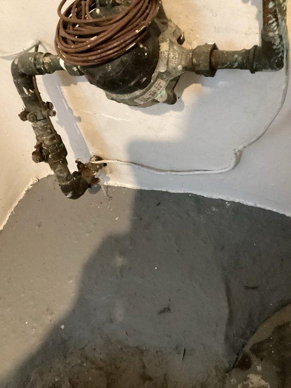 Replaced deteriorated shut-off valve on main water line that showed significant corrosion and mineral buildup. Installation included new valve assembly with proper fittings to connect to existing L-shaped pipe configuration. System was tested for proper operation and verified no leaks at connection points.