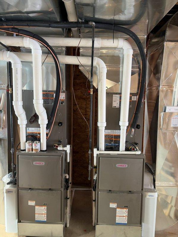 Completed rough-in installation of HVAC system in new construction, including running sleeves and linesets through wood framing. Installed dual Lennox furnace units in mechanical room with proper PVC venting, copper linesets, and connections to ductwork. Documented installation with photos showing both the rough-in work through framed walls and the completed mechanical room setup.