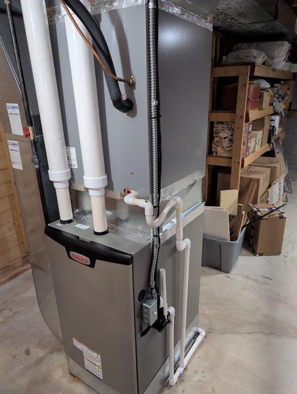 Completed retrofit installation of Lennox furnace system in basement utility area. Installed new PVC intake and exhaust venting, connected all electrical components and condensate drain lines, and secured proper ductwork connections with Lakes-branded components. System was properly mounted with appropriate clearance for maintenance access and verified to be in proper working condition.
