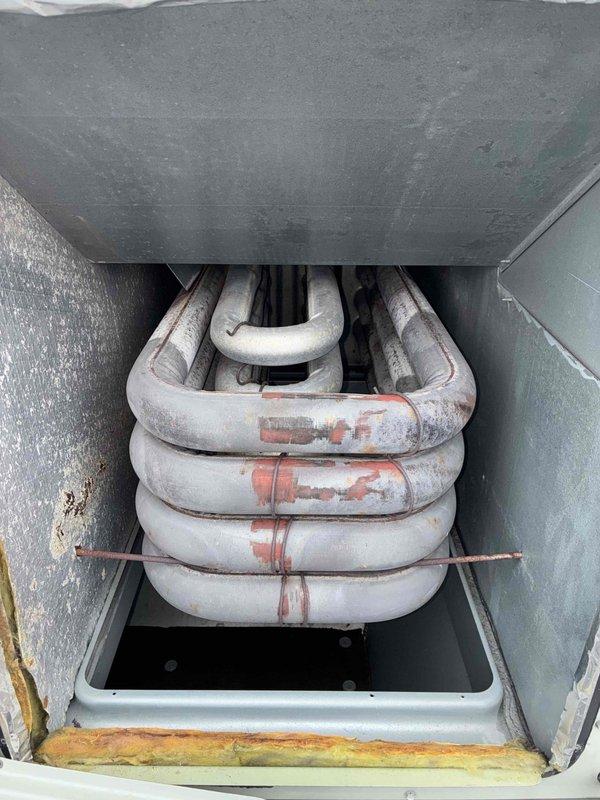 Performed scheduled commercial heating system maintenance and inspection. Observed significant corrosion on evaporator coil assembly with rust development on metal components. Documented electrical wiring condition and identified deterioration of mounting brackets requiring future attention.