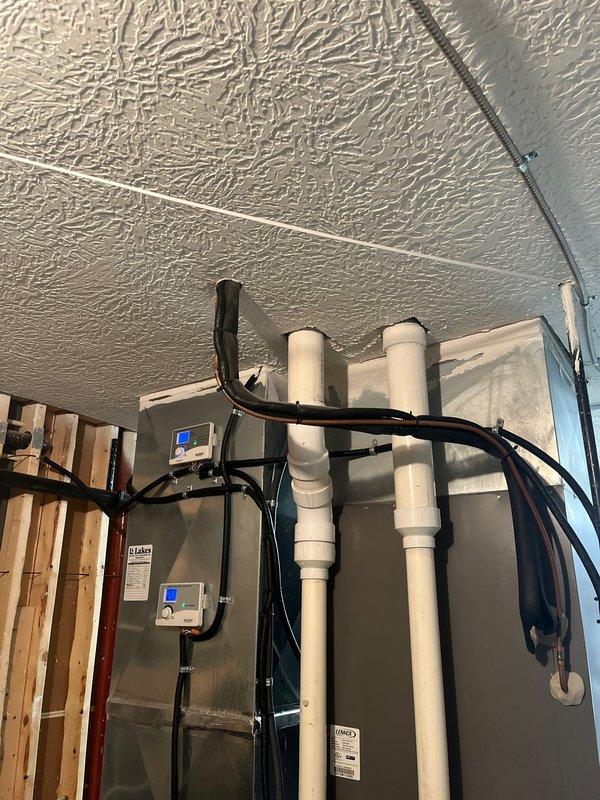 Completed air conditioning retrofit assessment, documenting existing mechanical system configuration with digital photography. Evaluated current furnace/air handler unit with exposed internal components, condensate lines, refrigerant piping, and associated control systems. Prepared comprehensive replacement estimate for upgrading the existing HVAC equipment.