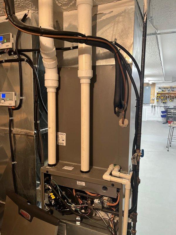 Completed air conditioning retrofit assessment, documenting existing mechanical system configuration with digital photography. Evaluated current furnace/air handler unit with exposed internal components, condensate lines, refrigerant piping, and associated control systems. Prepared comprehensive replacement estimate for upgrading the existing HVAC equipment.