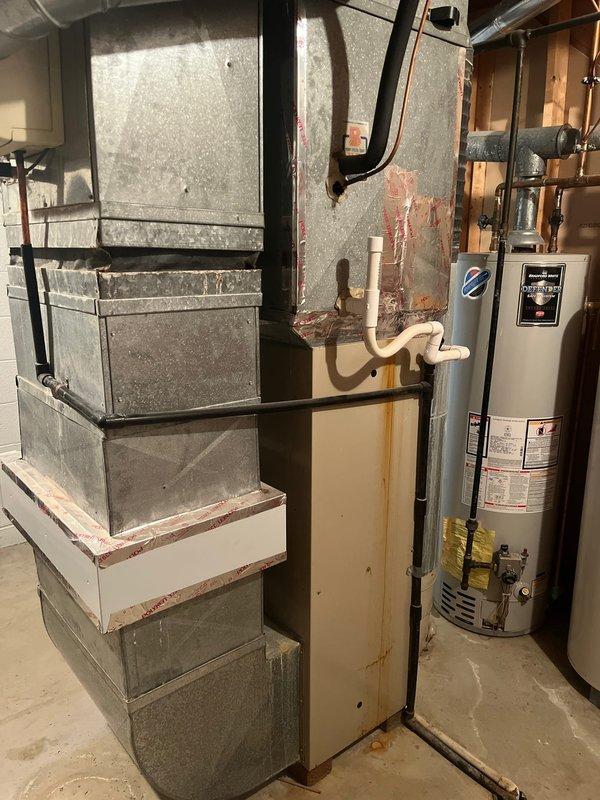 Completed furnace retrofitting in utility room of residential property. Existing HVAC system was evaluated alongside water heater configuration to ensure proper integration. Exterior electrical connections were inspected and secured with appropriate conduit installation to support the new equipment.