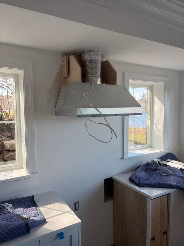 Completed final installation of a Lennox furnace system with associated ductwork in the residential mechanical room, ensuring proper connections to existing plumbing and electrical systems. Installed kitchen ventilation system with metal range hood and ductwork between windows, completing the HVAC new construction finish requirements for the property.