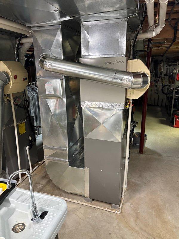 Completed furnace retrofit installation in basement utility room, replacing existing unit with new Lennox system featuring updated control panel and PVC venting. Installation included proper connection of all ductwork, exhaust components, and utility connections, with system testing and verification of proper operation completed.