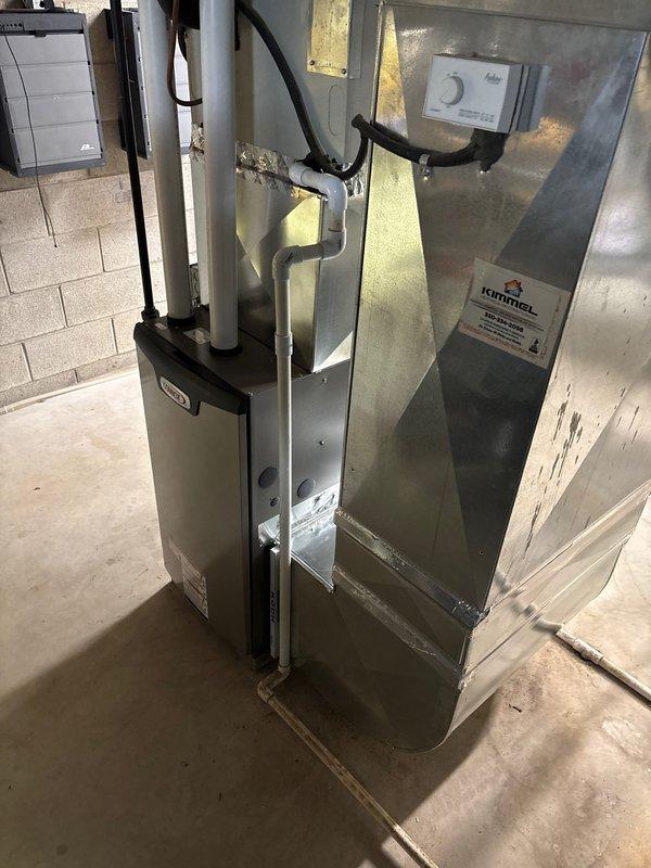 Completed furnace retrofit installation in basement utility room, replacing existing unit with new Lennox system featuring updated control panel and PVC venting. Installation included proper connection of all ductwork, exhaust components, and utility connections, with system testing and verification of proper operation completed.