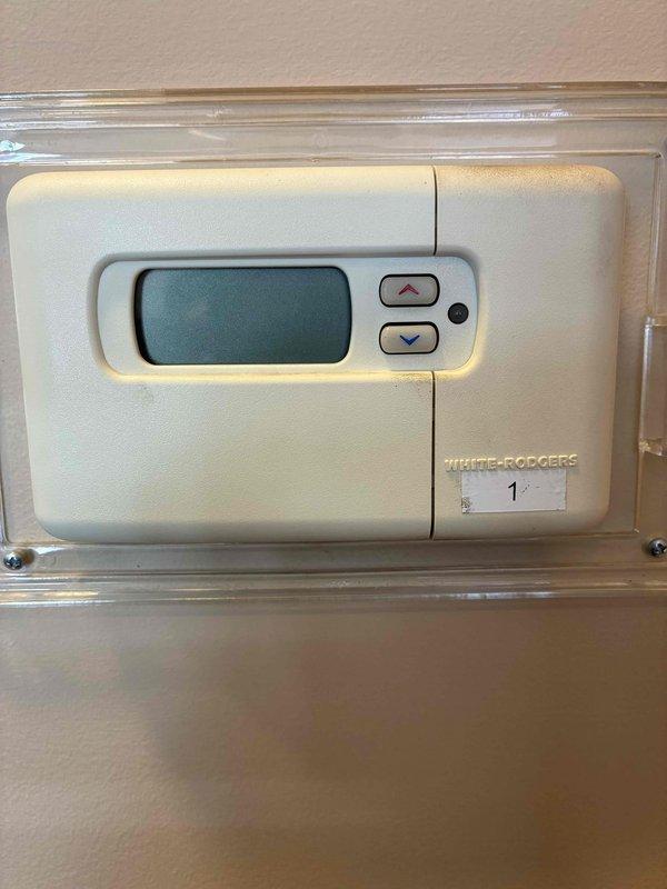 Responded to service call for non-functional thermostat after a power outage. Upon arrival, found White-Rodgers digital thermostat with blank display. Restored power to the thermostat, confirmed proper operation with display showing 70° temperature reading and "AUTO" mode functioning correctly.