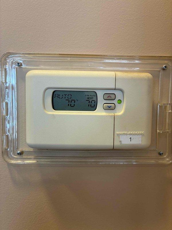Responded to service call for non-functional thermostat after a power outage. Upon arrival, found White-Rodgers digital thermostat with blank display. Restored power to the thermostat, confirmed proper operation with display showing 70° temperature reading and "AUTO" mode functioning correctly.