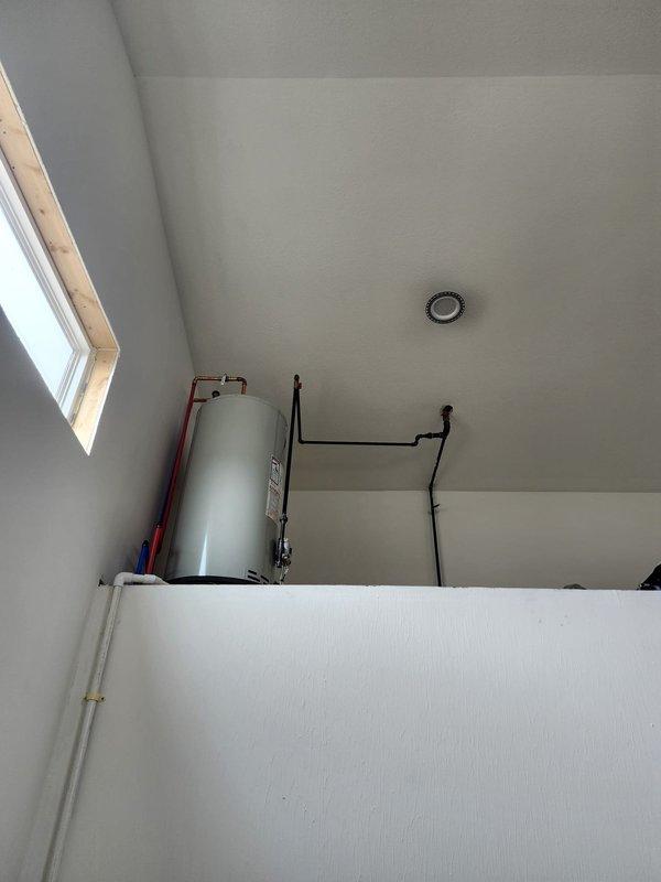 Conducted inspection of water heater venting system installed above bathroom area. Verified proper installation of hot and cold water lines, examined black venting pipes for proper routing and clearances. No issues requiring immediate attention were identified during this preventative maintenance visit.