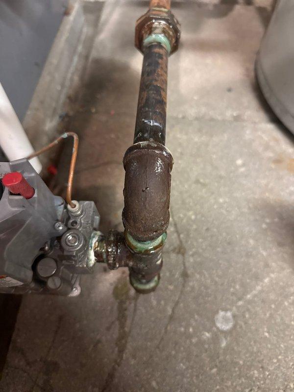 Responded to service call for a boiler making unusual noise. Upon inspection, found significant corrosion on horizontal pipes and control valve assembly with mineral buildup at connection points. Observed advanced oxidation and galvanic corrosion at brass/copper fittings, indicating long-term moisture exposure or possible slow leak causing deterioration of metal components.