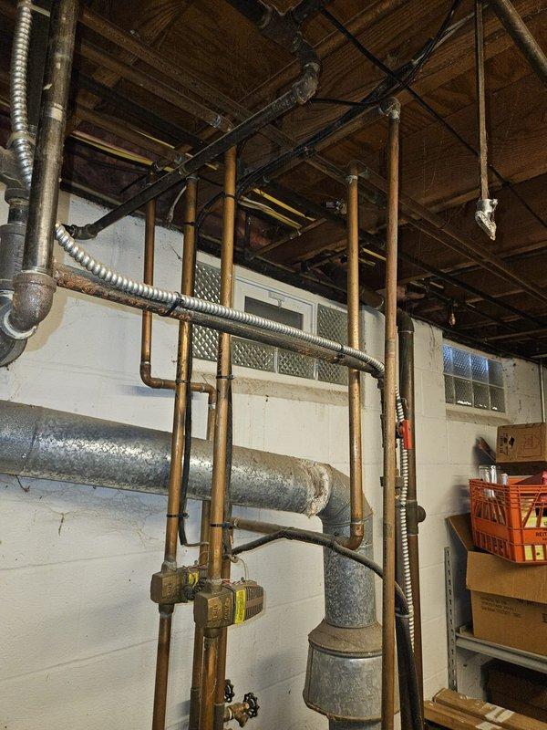 Performed diagnostic assessment on aging boiler system in 1976 home where customer reported furnace not working. Visual inspection revealed older copper piping with oxidation and aging components, including expansion tank and pressure relief valves. System appears to be a standard residential hydronic heating installation requiring further evaluation for proper functionality.
