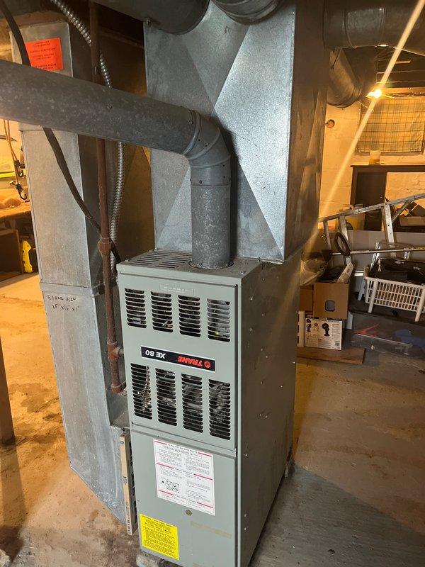 Completed installation of AC add-on to existing Trane XR 80 furnace system in basement. Inspected and verified proper connection of ductwork, including rectangular and round pipes, to accommodate new AC components. Ensured all ventilation, copper gas piping, and electrical connections meet code requirements for the integrated HVAC system.