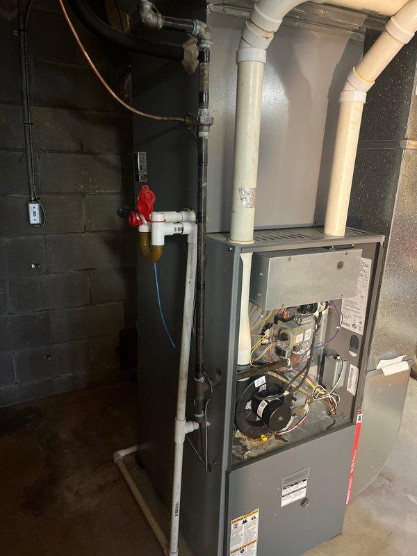 Conducted HVAC system evaluation and provided replacement estimate for residential gas furnace with confirmed cracked heat exchanger. Unit was photographed showing open access panels with internal components exposed, including blower assembly, gas valve, electrical connections, and heat exchanger assembly. Despite the compromised heat exchanger—a critical safety concern that can allow carbon monoxide infiltration into living spaces—the furnace was still operational at time of inspection. Documented existing installation including white PVC intake and exhaust venting, gas line connections with shutoff valves, electrical service, and associated ductwork connections. Presented comprehensive replacement options to address the failed heat exchanger and ensure safe, efficient heating system operation.