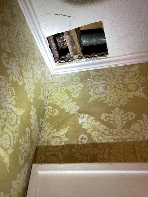 Responded to water leak complaint and performed investigative opening of bathroom ceiling to locate source of water intrusion. Removed section of ceiling drywall at wall-ceiling junction to expose plumbing lines and structural framing. Investigation revealed evidence of active water damage with visible mold growth and deterioration on wooden framing members. Documented existing conditions with photographs showing compromised building materials, water staining, and structural exposure. Provided estimate for necessary repairs including water damage remediation, mold treatment, and ceiling restoration work.