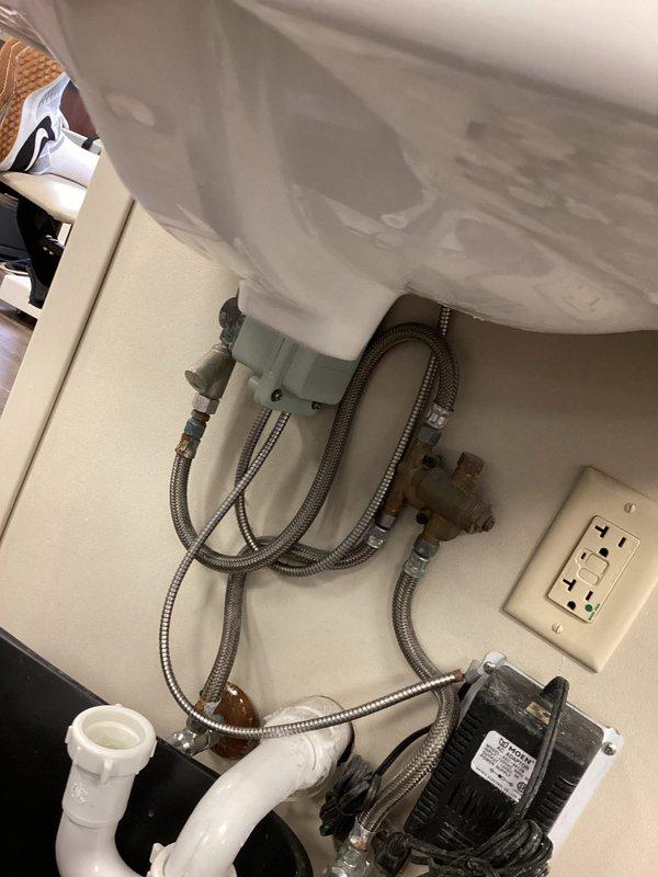 Responded to bathroom sink leak complaint and performed thorough inspection of plumbing system. Upon examination, documented existing plumbing configuration including P-trap assembly, supply line connections, and shut-off valves. Noted visible water damage on flooring near base of wall indicating active or recent leak. Inspected all flexible braided supply lines, compression fittings, and drain connections for signs of moisture or failure points.