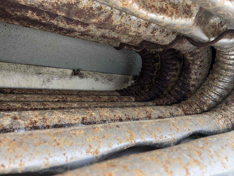 Completed fall maintenance inspection on commercial HVAC system. Documented severe corrosion throughout evaporator coils and refrigerant piping, with extensive rust, oxidation, and mineral deposits indicating prolonged moisture exposure and deteriorated system components requiring immediate attention and potential replacement to prevent system failure.
