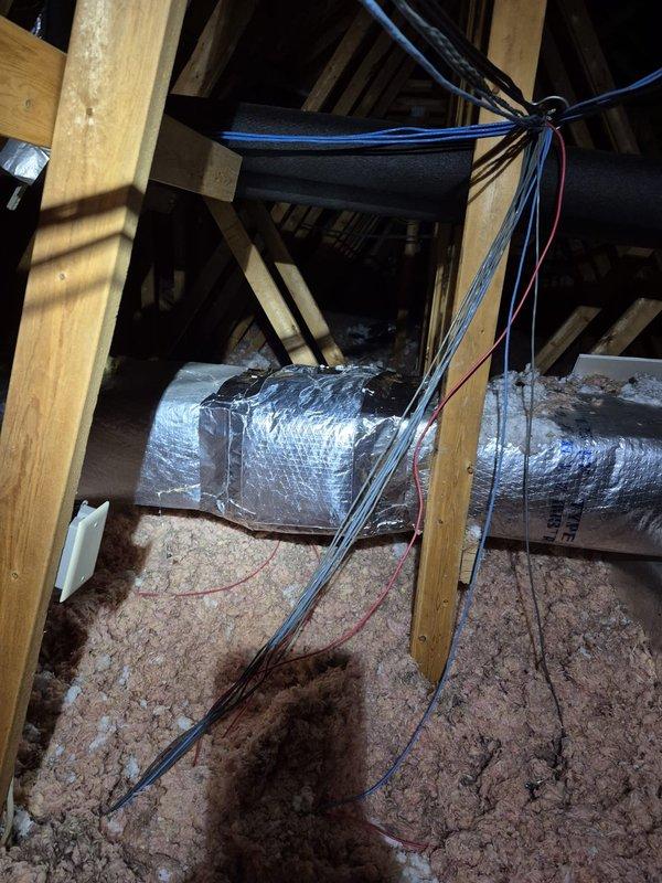 Responded to attic ductwork repair request and found severely deteriorated flexible duct with torn outer vapor barrier and exposed internal insulation causing significant air leakage and energy loss. Removed damaged flexible duct section, installed new properly-sized flexible ductwork with intact insulation and vapor barrier, secured all connections with mastic and metal straps per code requirements, and supplemented attic floor insulation with additional pink fiberglass batts to restore proper R-value and thermal efficiency.