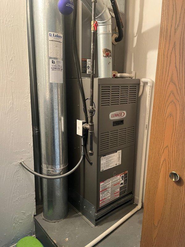 Completed furnace replacement with new Lennox unit installed in residential utility space. System properly positioned, connected to existing ductwork, and vented according to manufacturer specifications with all electrical and gas connections secured and tested for safe operation.