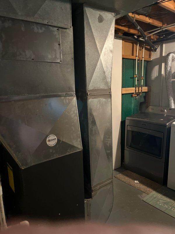 Completed furnace and air conditioning system retrofit in residential basement utility area. Removed existing HVAC equipment and installed new heating and cooling system with updated ductwork connections, ensuring proper integration with existing infrastructure including water heater and electrical systems. All equipment tested and operational upon completion.