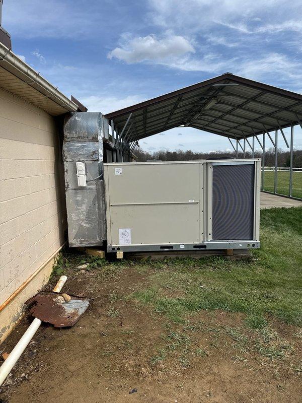 Successfully installed a Daikin 7.5-ton rooftop package unit for a commercial new construction project. The unit was positioned on a concrete pad at ground level adjacent to the building, with metallic ductwork connected vertically to the structure. Electrical disconnect box was wired and equipped with TR60R 600V AC fuses, ensuring proper overcurrent protection and safe disconnect capability for the equipment.