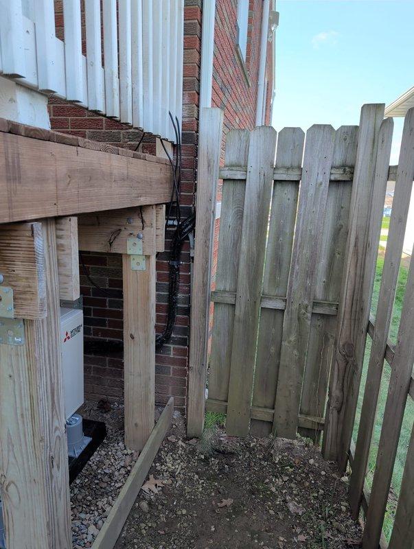 Completed installation of ductless mini-split system in basement with indoor unit mounted on interior wall and outdoor condenser positioned under deck. Line set was concealed along exterior of building using protective channel, with refrigerant lines and control wiring routed from basement unit to outdoor condenser. Connected system to existing electrical supply and performed startup, vacuum, and refrigerant charge procedures to ensure proper operation.