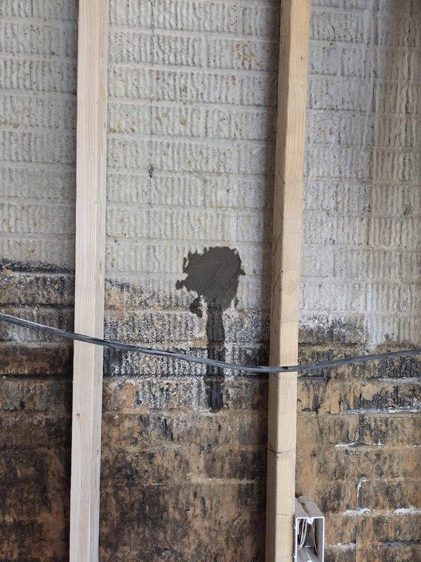 Conducted site assessment for new construction ductwork installation in addition area. Documented existing conditions including interior wall framing, concrete block foundation walls, and structural elements to determine optimal routing for HVAC distribution system. Identified areas requiring coordination with existing building envelope and noted moisture-affected zones in lower wall sections that will need remediation prior to duct installation and insulation work.