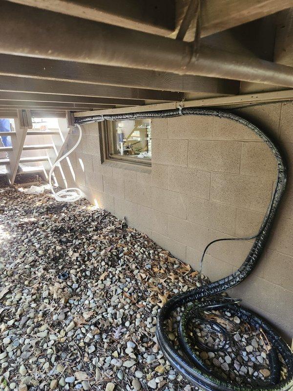 Completed rough-in installation for mini split system at new construction residential property. Ran refrigerant line set and electrical conduit from exterior wall penetration through crawl space beneath floor joists to designated equipment location. Secured all piping and wiring per code requirements, coordinated with project manager to ensure proper placement for final equipment installation phase.