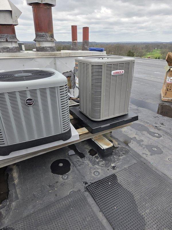 Completed full HVAC system replacement on rooftop installation. Removed existing equipment and installed new Ruud and Lennox condensing units on vibration-dampening pads with proper wooden support platforms. Units positioned on gray membrane roofing surface with appropriate spacing for service access and airflow. Ran new electrical wiring including 6-foot loom, flex conduit, and 18-gauge wire as documented. Installed electrical connections using 3/4-inch and 3/8-inch conduit fittings, couplers, and 90-degree elbows per code requirements. Verified proper unit mounting, secured all electrical connections, and confirmed system startup. All equipment labeled and documented for future reference.