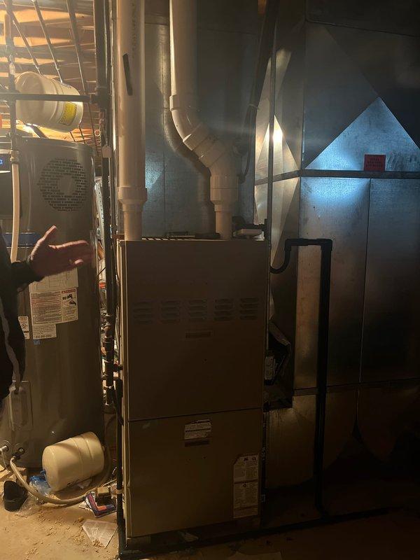 Completed full HVAC system installation for new construction residential property, including outdoor condenser unit with protective wire mesh enclosure and complete indoor air handling equipment with furnace system in basement mechanical room. All equipment installed to manufacturer specifications with proper venting, ductwork connections, and electrical hookups, resulting in fully operational heating and cooling system.