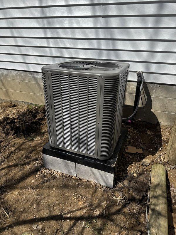 Completed new construction HVAC installation including refrigerant line set, outdoor condensing unit, and final system commissioning. Installed Lennox air conditioning condenser on elevated pad with proper foundation support, ran electrical conduit and refrigerant lines to exterior wall penetration, and verified all connections for proper operation. System tested and left operational for customer use.